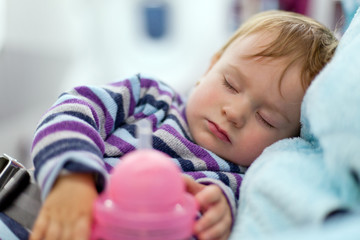 Mother and sleeping two year old baby girl travel on airplane