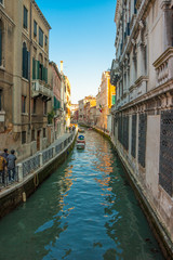 Fototapeta na wymiar Zbieżne widok budynków wzdłuż kanału w Wenecji i chodnik