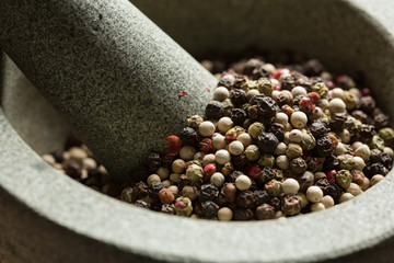 Mixed peppercorns in mortar with pestle