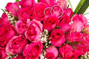 wedding rings and bridal bouquet of pink roses isolated over whi