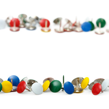 colorful drawing pins / thumb tacks against a white background w