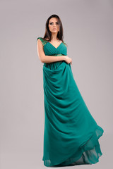 Naklejka premium portrait of sexy girl in green dress on gray background