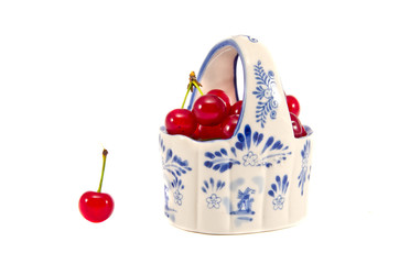 ceramic basket with red cherries isolated on white