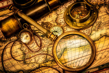 Vintage magnifying glass lies on an ancient world map