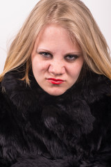 cocky angry young cute young woman in fur jacket