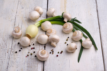 Fototapeta na wymiar Fresh mushrooms and onion on a wooden board