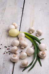 Fresh mushrooms, onion on a wooden board