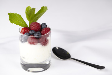 Joghurt mit Beeren und Pfefferminzzweig