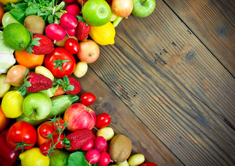 Fresh fruits and vegetables on the old wooden board