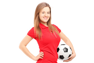 A young smiling female holding a soccer ball