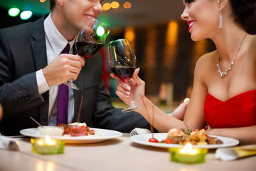 Attractive young couple drinking red wine in restaurant