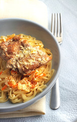 Noodles with rabbit stewed with carrots and onions in sour cream