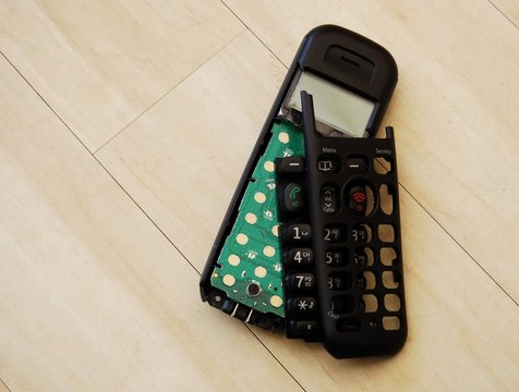 Broken phone handset on wooden floor