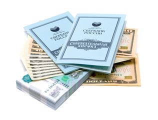 Two savings books lie on a stack of money on white background