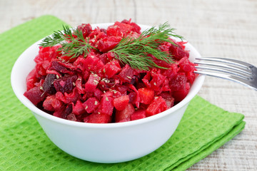 Vinaigrette salad with dill. On the table with fork and green na