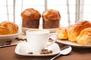 morning breakfast with coffee milk, croissants and muffins