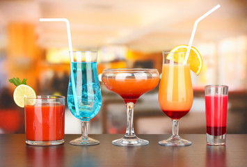 Several glasses of different drinks on bright background