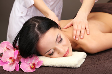 Obraz na płótnie Canvas Beautiful young woman in spa salon getting massage with spa