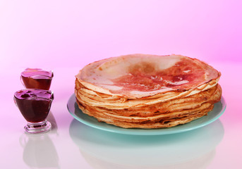 Pancakes on plate on pink background