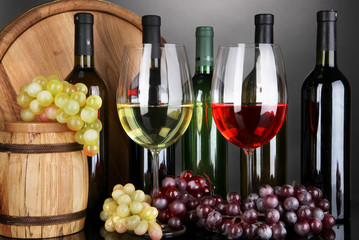 Assortment of wine in glasses and bottles on grey background