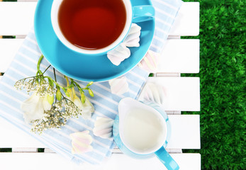 Beautiful tea composition on wooden picnic table close-up