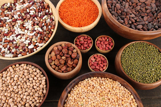 Different kinds of beans in bowls on  table close-up