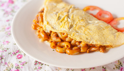 Fried macaroni with tomato sauce wrapped with omelette
