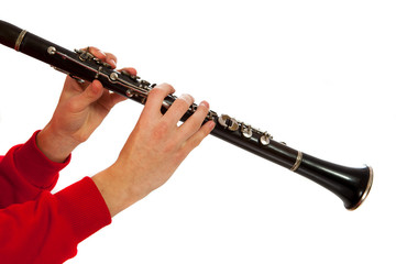 Hands playing on clarinet. Isolated over white background