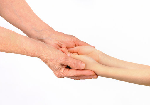 Hands of the old woman embracing hands of grandchild