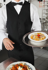 Waiter Holding Dish In Kitchen