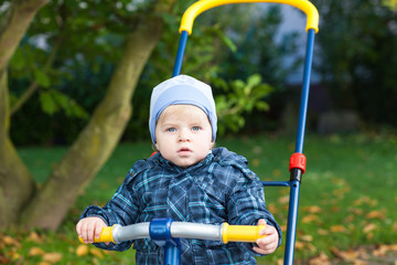 Little toddler boy in autumn park