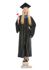 Happy young woman in graduation gown with diploma 