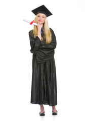 Full length portrait of woman in graduation gown with diploma