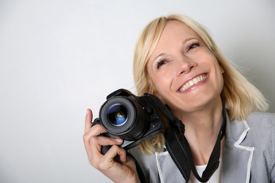 Cheerful woman photographer holding camera