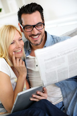 Couple at home reading news