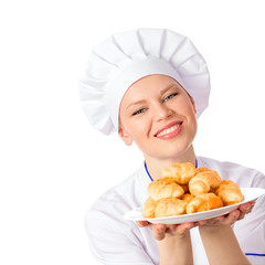 Portrait of young woman baker with hot croissants on plate
