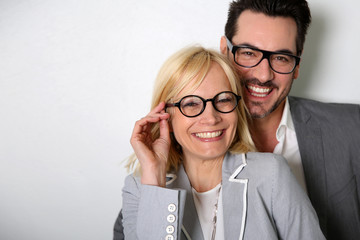 Cheerful couple with eyeglasses on white background