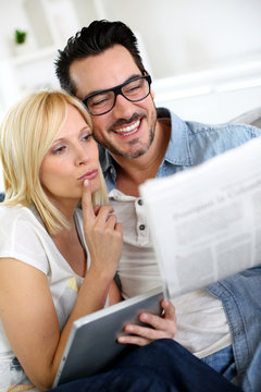 Couple at home reading news