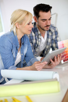 Middle-aged couple choosing wall colours for new home