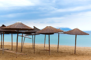 Fototapeta na wymiar Parasol słomy na plaży w godzinach porannych błękitne niebo latem wakacje