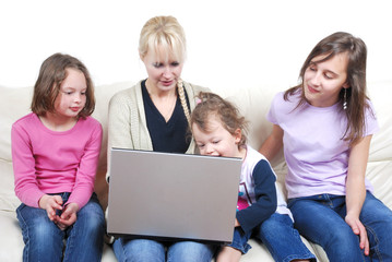 Family sitting on the sofa and using laptop