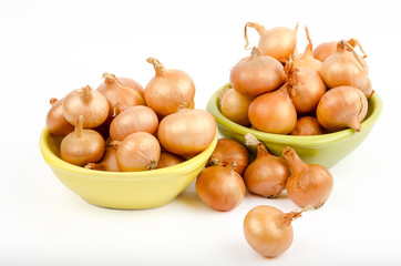 Two bowls full of onions on a white background