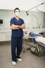 A portrait of a dentist with his patient at background