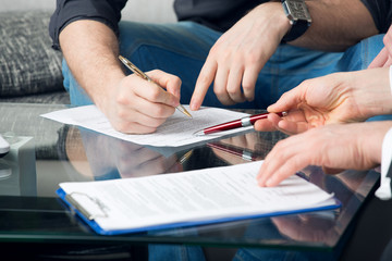 Two people signing a document