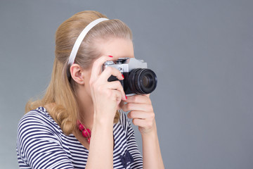 young woman in retro clothes posing with photo camera