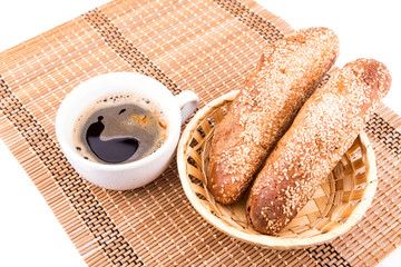 Freshly baked bread rolls with sesame with cup of coffee