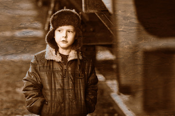 Retro black and white photo of sepia Boy homeless bum on street