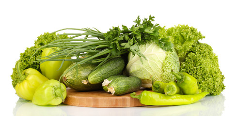fresh green vegetables on chopping board isolated on white