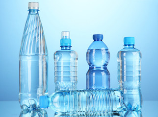 Naklejka premium Different water bottles on blue background
