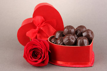 Chocolate candies in gift box, on grey background